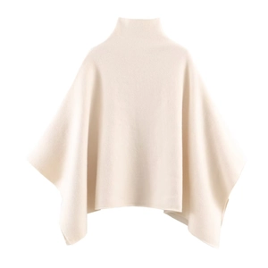 Détail d'une cape en tricot crème avec col roulé et texture côtelée douce au toucher
