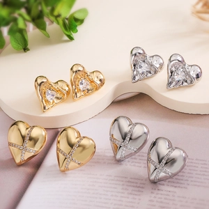 Gold and silver heart stud earrings with cubic zirconia on elegant display