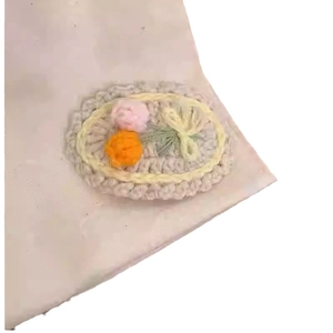 Handmade knitted hair clip with embroidered pink flowers and bow on beige base
