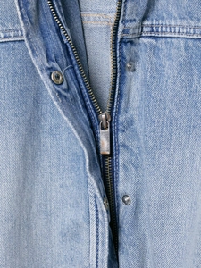 Close-up of smooth metal zipper and silver snap buttons on blue denim jacket