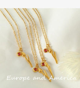 Macro detail of tulip pendant with red zircon stone and gold plated O-chain necklace