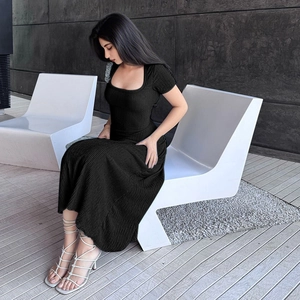 Détail d'une robe noire en maille à col carré avec manches courtes et fente latérale