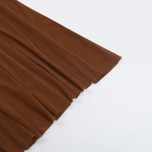Détail de la maille transparente marron avec texture plissée élégante sur une robe