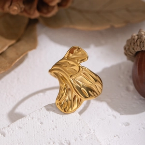 Artistic gold petal ring on stone base with autumn pine cones for a high-end luxury look