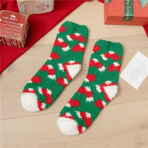 Detail of green coral fleece Christmas socks with festive patterns and gift box decor