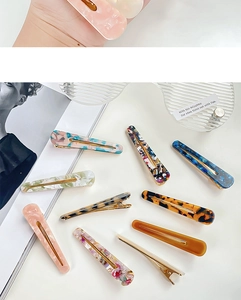 Flat lay of multiple acetate hair clips in tortoiseshell and marble patterns
