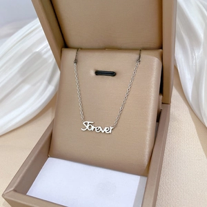 Silver titanium steel necklace with Forever pendant displayed in a beige jewelry box