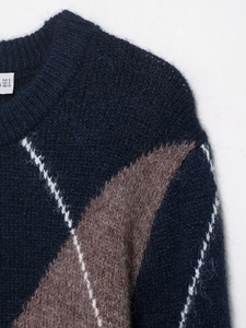 Detailed view of the diamond pattern knit and textured wool blend fabric on a navy sweater