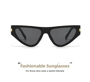 Detail of chic black cat-eye sunglasses with golden metal hinges and dark grey lenses