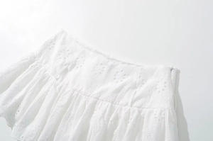 Detailed close-up of white lace skirt with floral embroidery and invisible side zipper