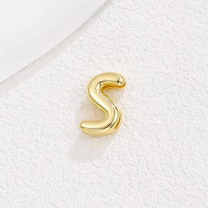 Macro detail of a 10mm gold-plated alphabet S pendant charm for DIY bracelet straps