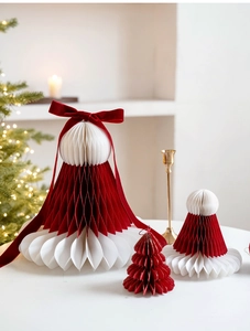 Détail d'ornements de Noël en papier nid d'abeille rouge et blanc avec nœud en velours