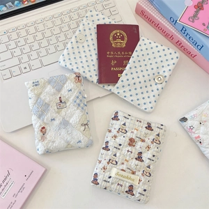 Close-up of quilted cotton passport covers with bear and polka dot patterns on a desk