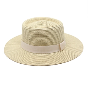 Detailed close-up of a light beige flat-top woven straw hat with a matching ribbon trim