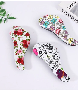 Detailed view of hair brushes with floral patterns and cartoon graphics on white surface