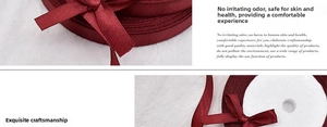 Detail of wine red satin ribbon tied in a bow on white plush background for gifts