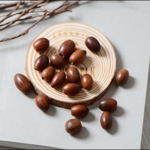 Macro detail of natural dried acorns on a wooden coaster for Christmas floral decoration