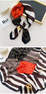 Detail of multi-pattern silk scarf featuring orange floral, stripes and houndstooth design