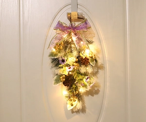 Detail of Christmas teardrop swag with golden berries, purple ribbons, and LED lights