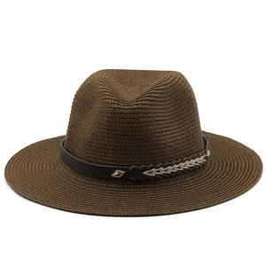 Detailed view of dark brown straw fedora with patterned band and metallic studs