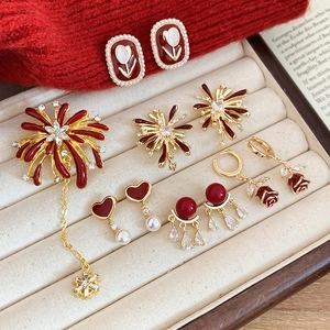 Collection of vintage red enamel earrings and jewelry on a premium velvet tray