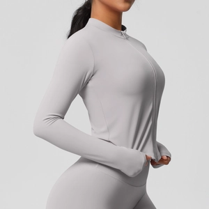 Détail d'une veste de yoga grise ajustée avec col montant et passants de pouces