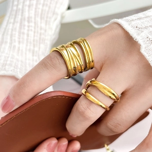 Detail of 18K gold plated multi-layer knotted cross rings worn on fingers