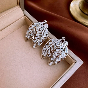 Macro shot of silver leaf tassel earrings with clear cubic zirconia in jewelry box