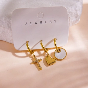 Detail of 14K gold-plated earring set with cross, heart and shell stone charms