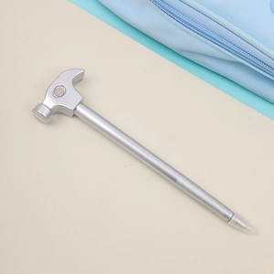 Close-up of a creative hammer-shaped silver ballpoint pen on a minimalist background