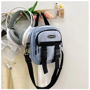 Dettaglio della mini borsa messenger in nylon celeste con doppie fibbie e tracolla