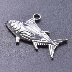 Macro view of a silver stainless steel fish pendant with polished finish and detailed scales