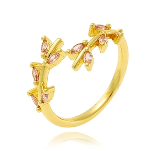Detail of gold branch ring with pink gemstone and zircon micro-pave on white background