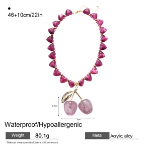 Detail view of acrylic cherry necklace showing size 6.7x7cm and heart beads chain
