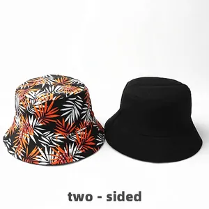 Reversible bucket hat with tropical leaf print and solid black breathable cotton side