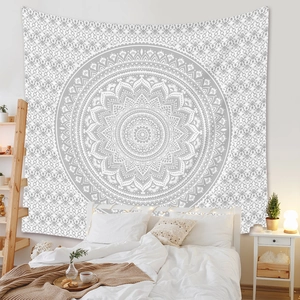 Détail d'une tapisserie mandala bohème suspendue comme décoration murale derrière un lit