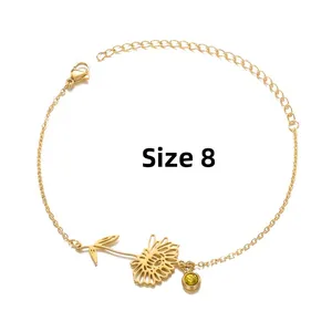 Detailed shot of gold sunflower bracelet with a yellow gemstone charm and lobster clasp