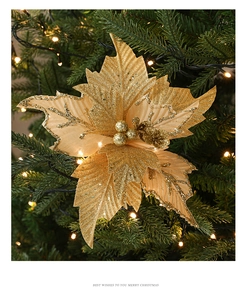 Golden glitter artificial Christmas flower ornament on tree with warm lights