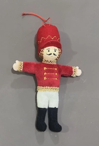 Detail of plush Nutcracker hanging ornament with red jacket and gold accents