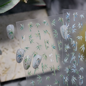 Detailed view of bamboo leaf nail art stickers with metallic iridescent finish on nails