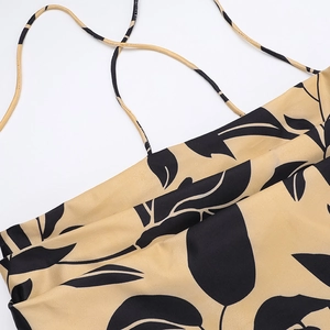 Detail of khaki dress with black leaf print and thin criss-cross spaghetti straps