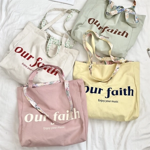 Detailed view of canvas tote bags with floral handles in four soft pastel colors
