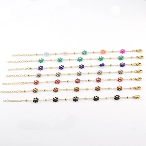 Set of seven stainless steel bracelets with colorful beaded flower charms on gold chains