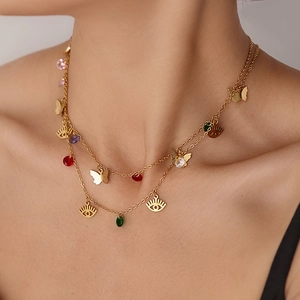 Detail of layered gold-plated necklace with colorful zircon pendants and evil eye charm