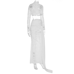 Detail of white lace two-piece set featuring sheer sleeves and ruched maxi skirt with ribbons