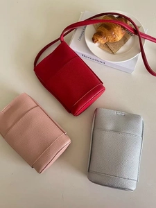 Detailed top view of mini crossbody phone bags in red, pink, and silver faux leather