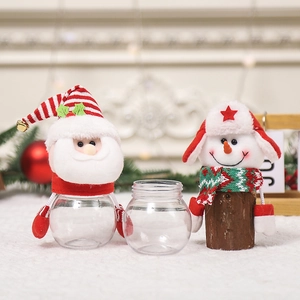Christmas candy jars with Santa and Snowman toppers on transparent holiday gift boxes