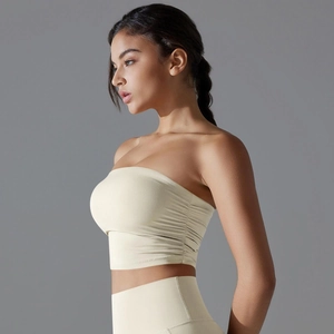 Vista lateral del top deportivo beige sin tirantes con detalles fruncidos y tejido sin costuras