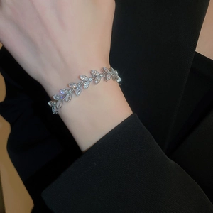 Détail d'un bracelet feuille en argent avec zircons étincelants sur manche noire