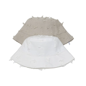 White and khaki distressed cotton bucket hats with frayed edges and tassel details